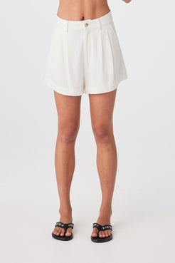 Close front view of cream boxy shorts showing fixed waistband and zip closure