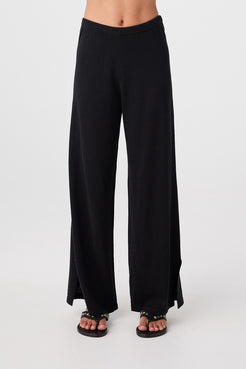 Close front view of black relaxed wide-leg pants showing ribbed elastic waistband