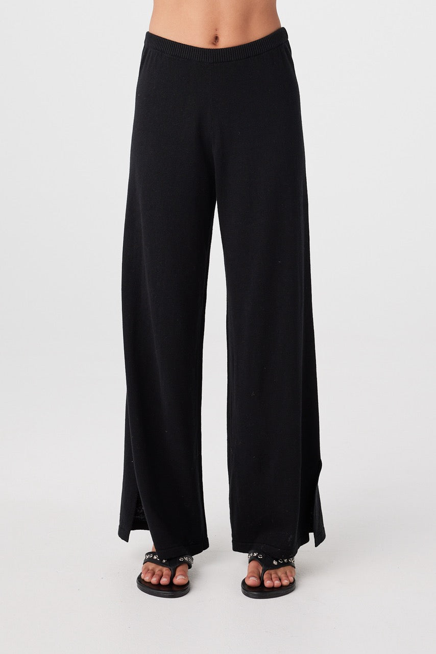 Close front view of black relaxed wide-leg pants showing ribbed elastic waistband