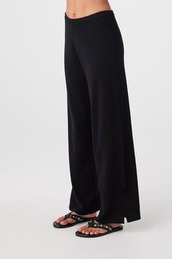 Side profile of woman in black wide-leg pants with soft drape