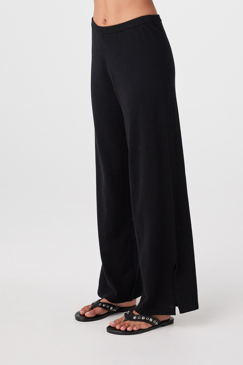 Side profile of woman in black wide-leg pants with soft drape