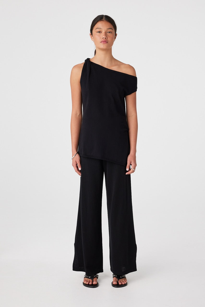 Full length front view of black asymmetrical one-shoulder cotton knit top and matching black pants