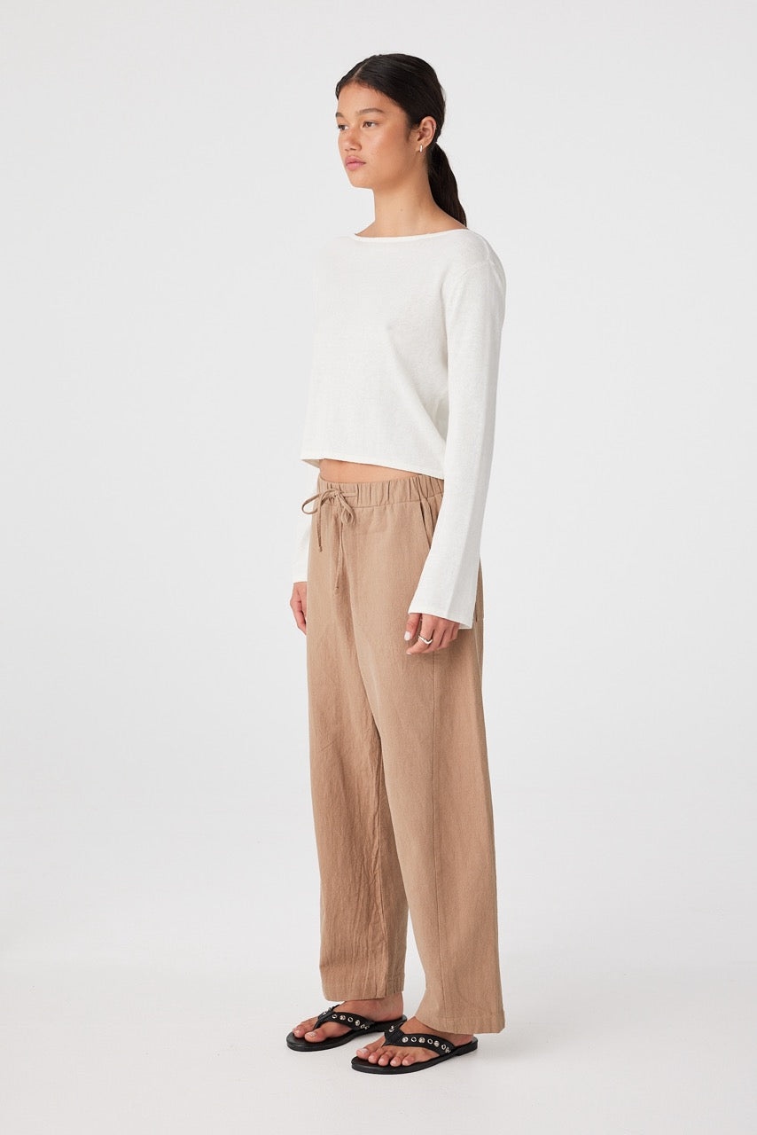 Side profile of cream reversible knit top with soft drape and scoop neckline