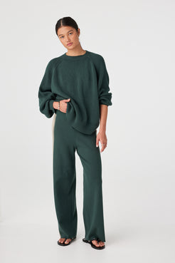Model wearing Forest high-rise straight-leg pants with contrast side stripe and ribbed drawcord waist, styled with chunky knit sweater