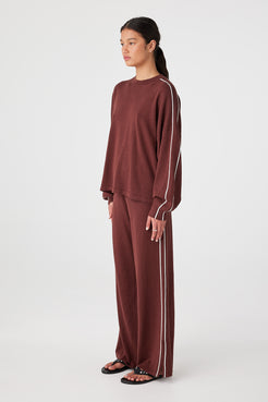 Side view of oversized long sleeve tee showing drop shoulder seam and loose sleeve shape