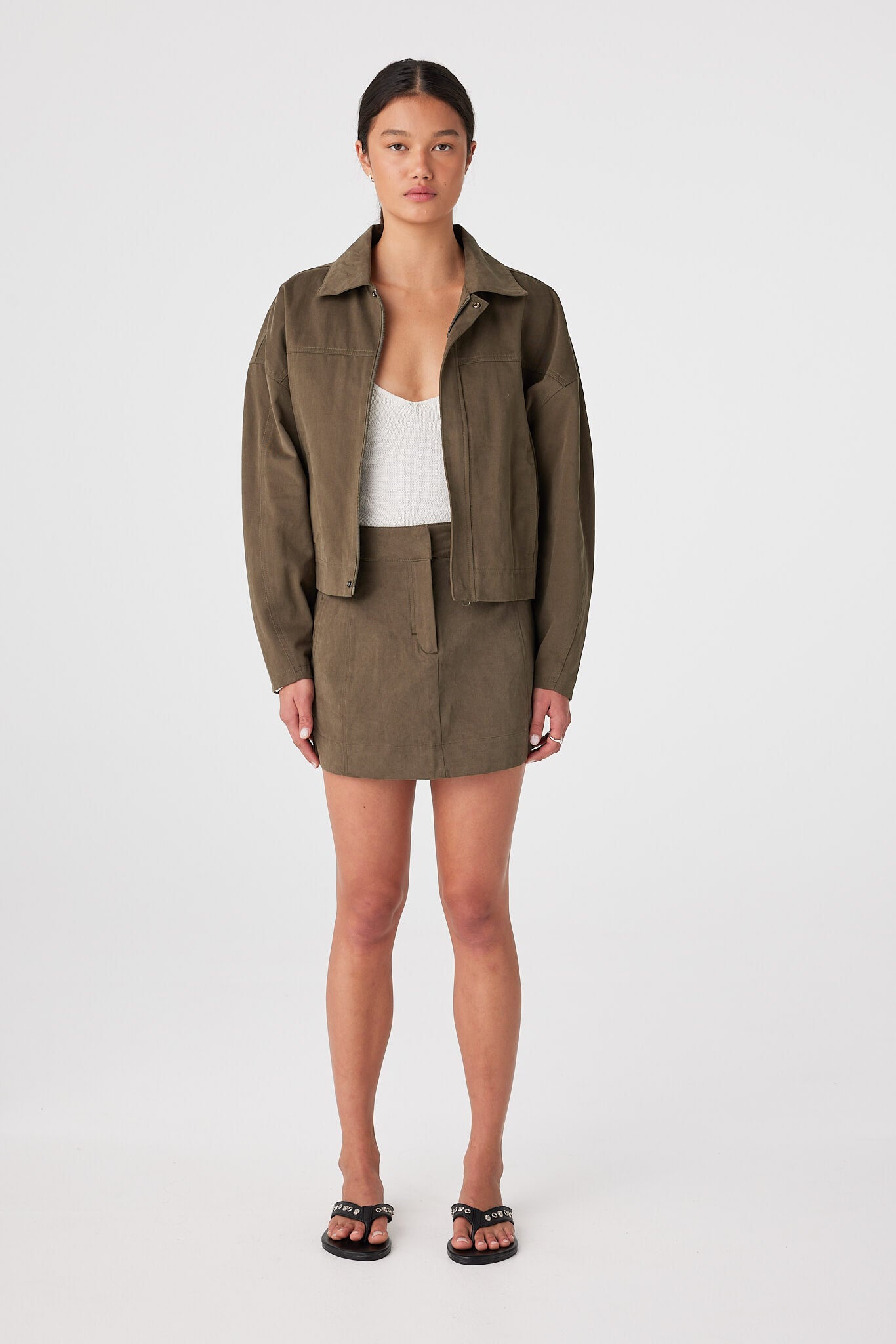 Khaki cropped boxy cotton jacket worn open, wide sleeves and utilitarian shape for mild-to-cool weather layering