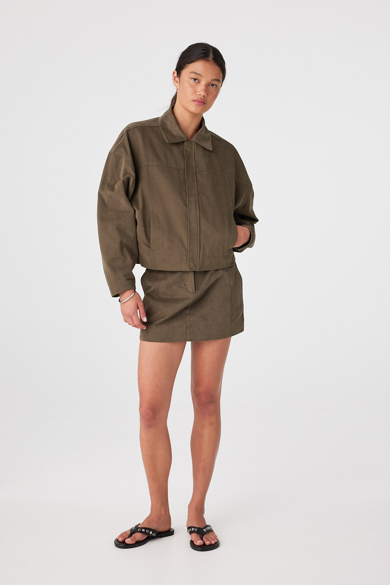 Khaki cotton jacket with velvet finish styled with matching mini skirt, utilitarian set for coastal evenings