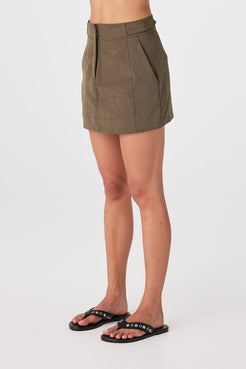 Three-quarter view of khaki mini skirt showing structured fit through hips and hem shape