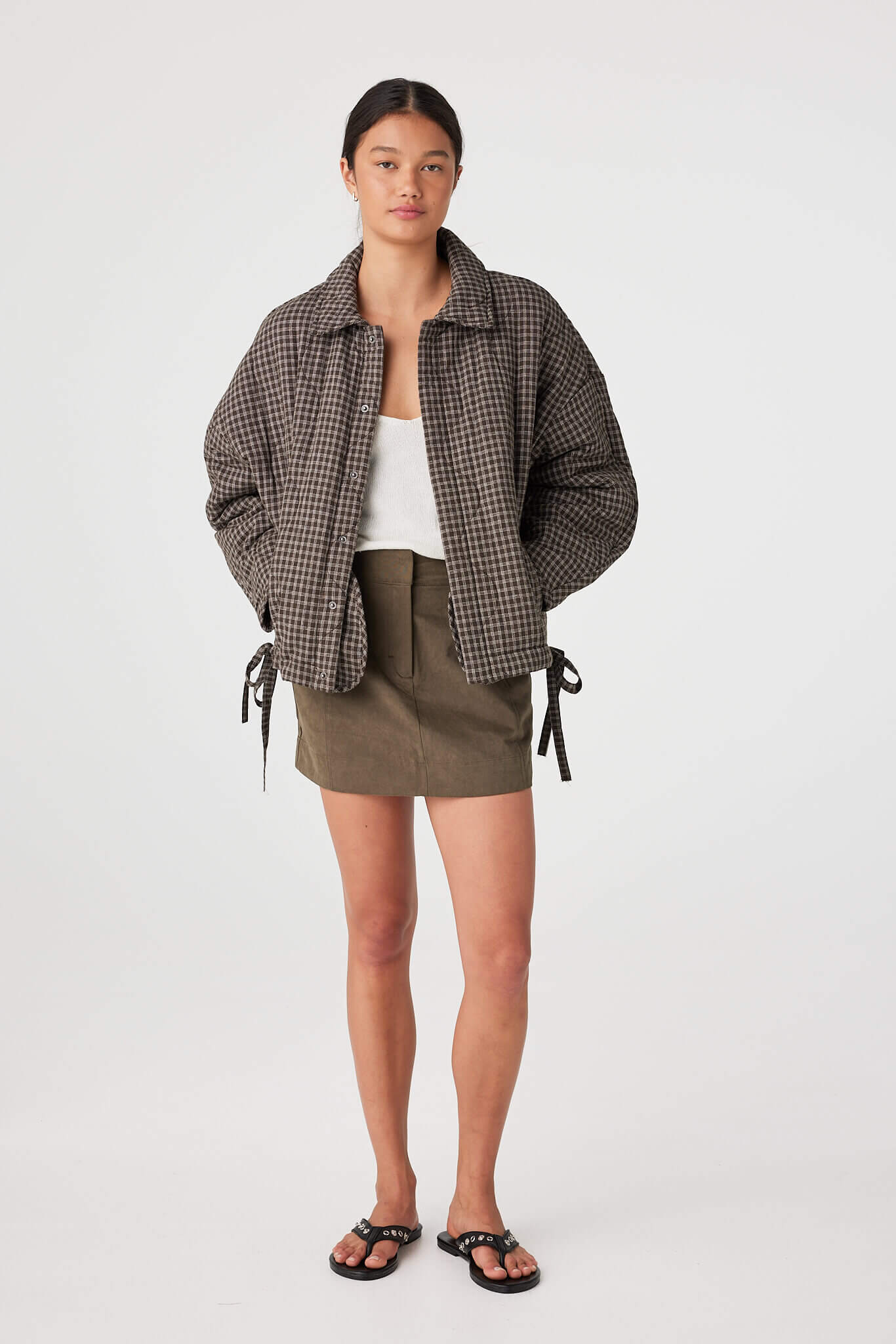 Three-quarter view highlighting quilt texture and check pattern on cotton jacket