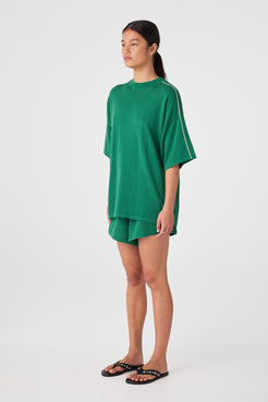 Sea green linen–cotton shorts styled with oversized tee, designed for warm-weather ease
