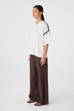 Side view of oversized knit tee showing relaxed sleeve width and drape through body