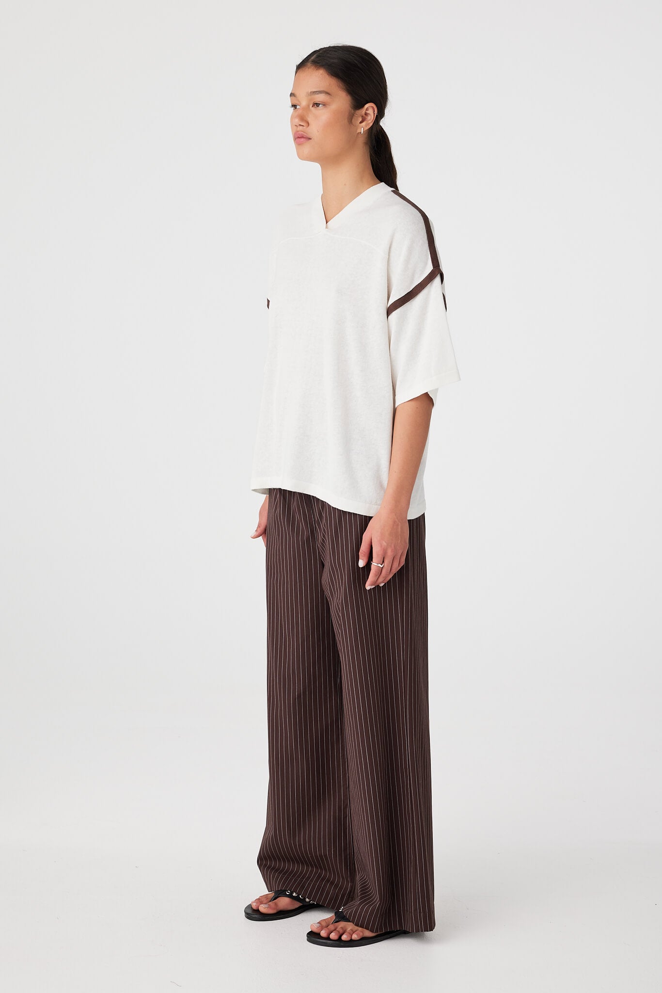 Side view of oversized knit tee showing relaxed sleeve width and drape through body