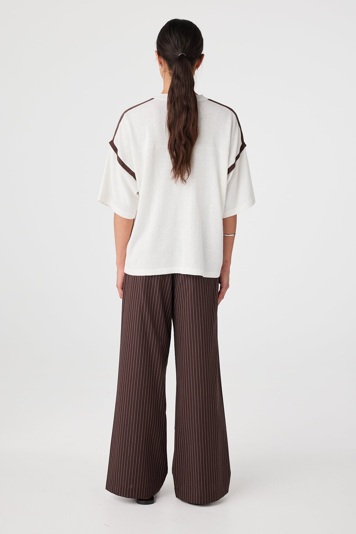 Back view of cream knit tee with espresso trim showing back yoke detail and loose fit