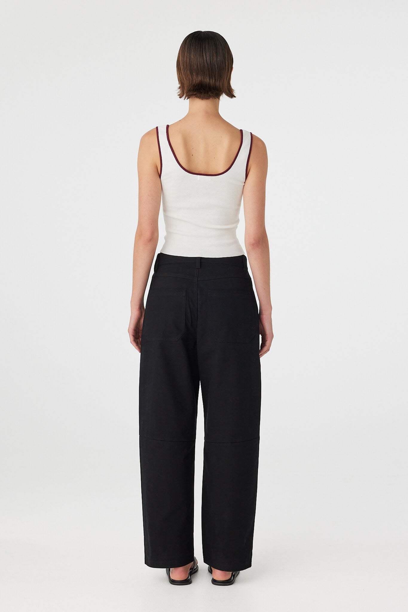 Back view of Akira Pant black, relaxed cotton pants with back patch pockets and full length leg shape.