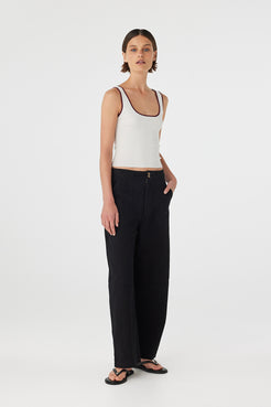 Full body view of Kaya Tank cream and merlot, slim organic cotton knit tank styled with black pants.
