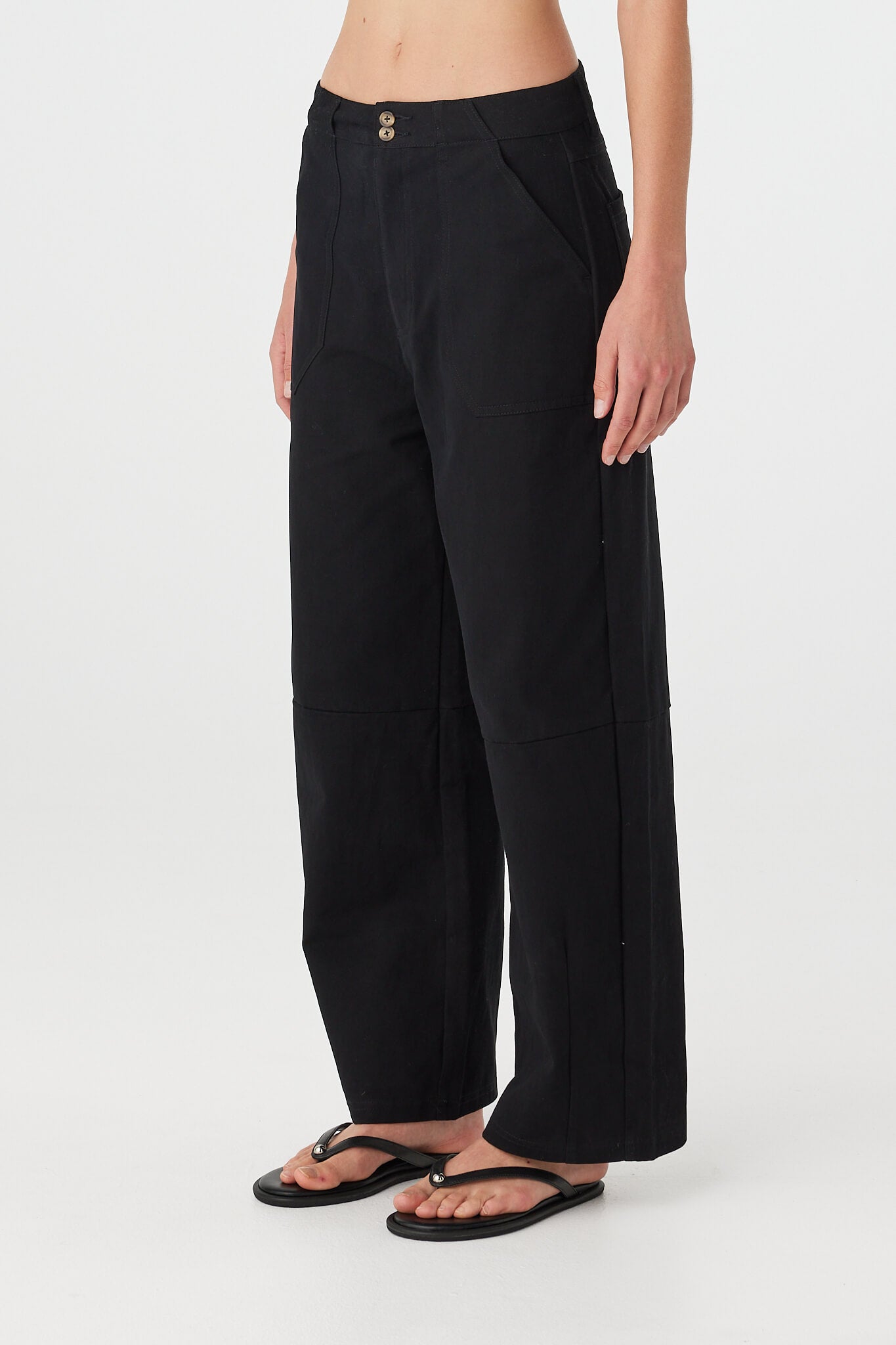 Akira Pant black cotton pants detail, zip fly with tortoise-effect button and front patch pocket opening.