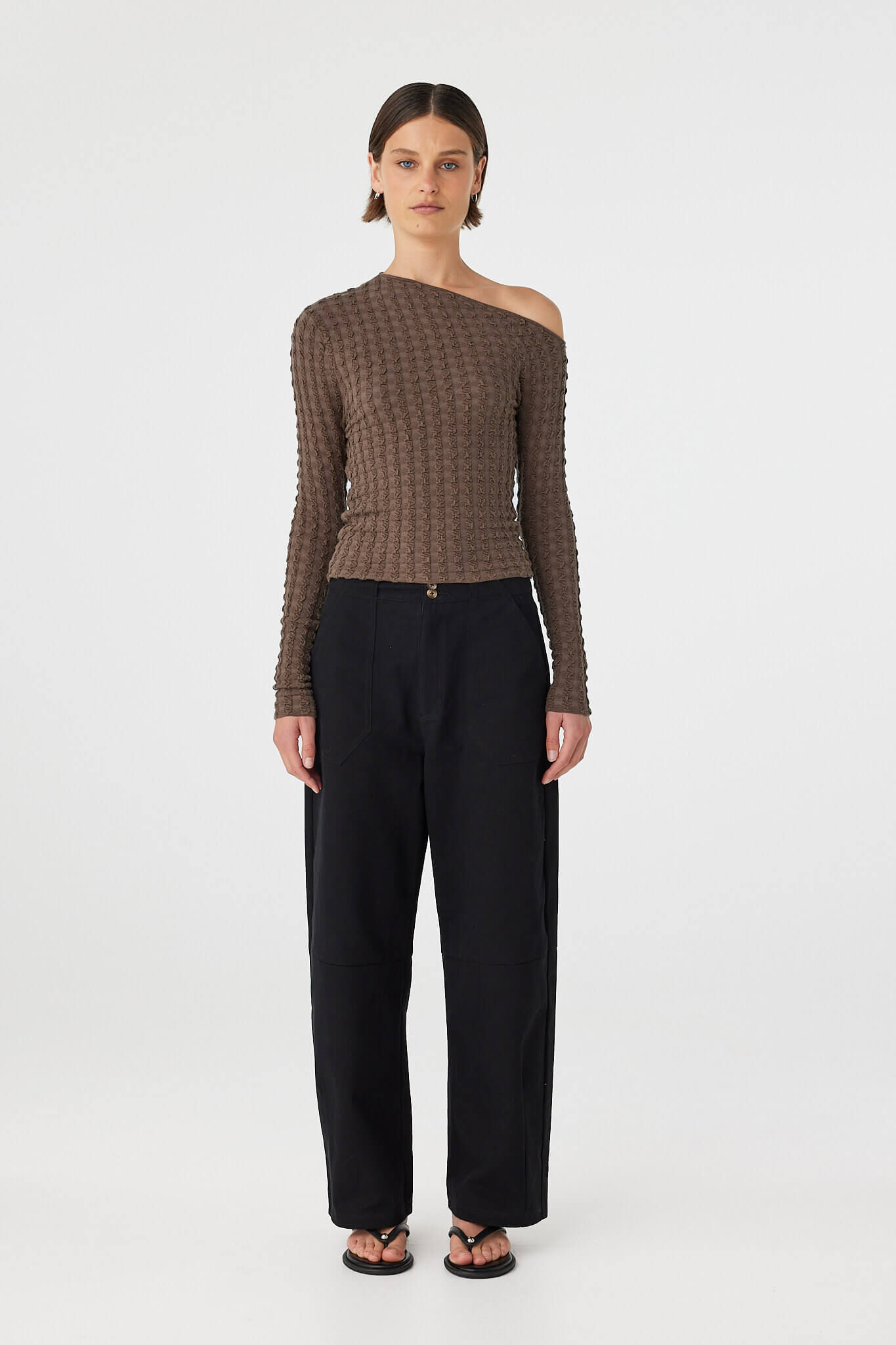 Full body front view of Sedona long sleeve top in Pavement paired with black pants