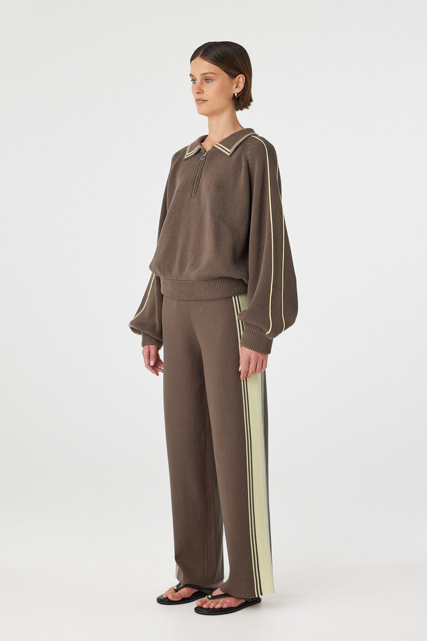 Side view of brown sweater showing raglan sleeves and piping detail