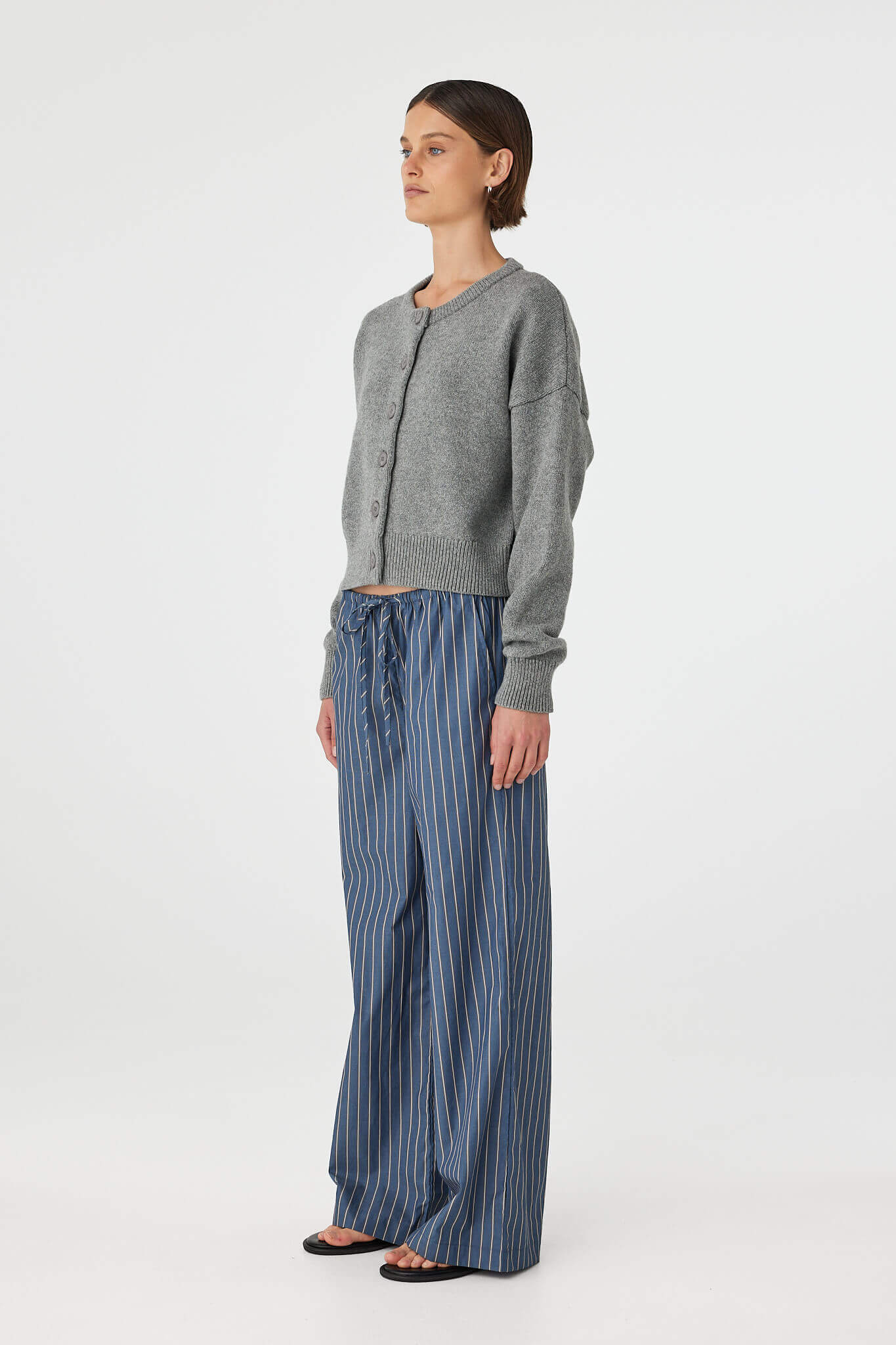 Side view of Bobby Cardigan in grey marle, button-up crew neck knit showing relaxed shape through the torso.