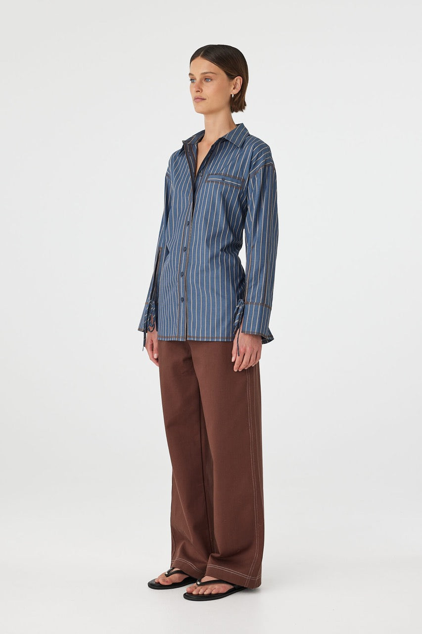 Side view of Blair Shirt in muted blue stripe, relaxed fit cotton shirt with long sleeves and cuff ties.