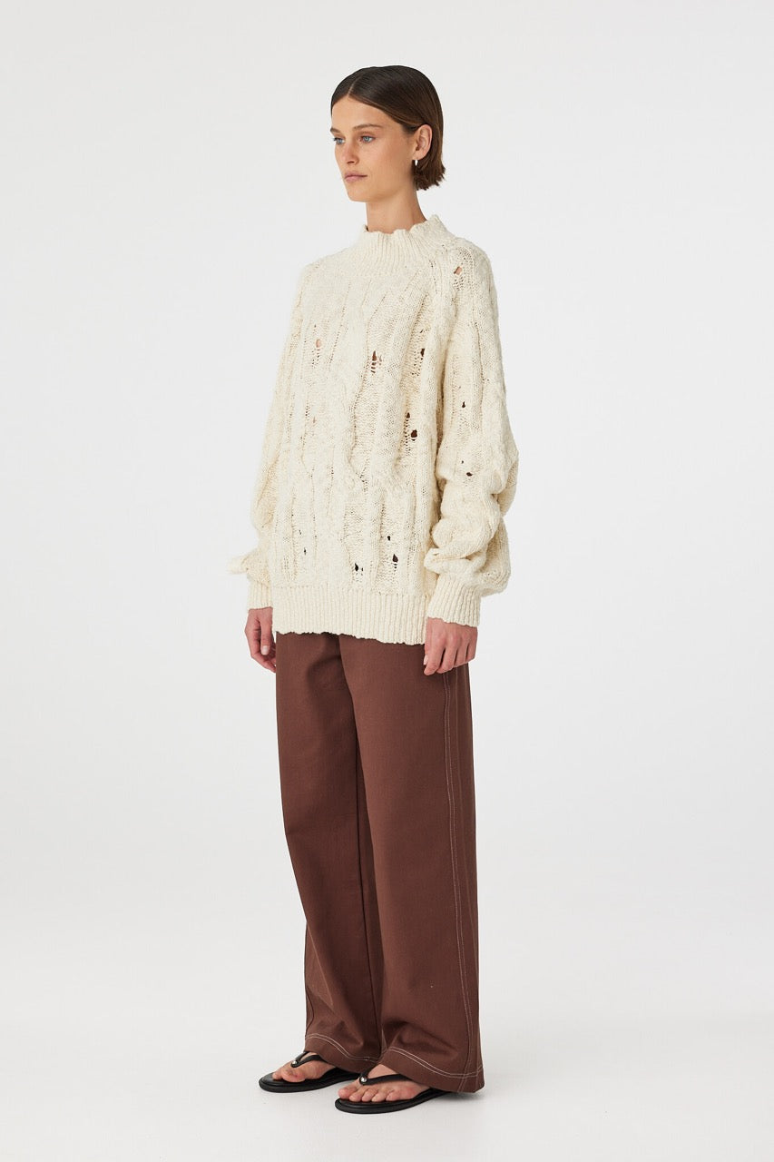 Side view of cream sweater with raglan sleeves and cuff detail