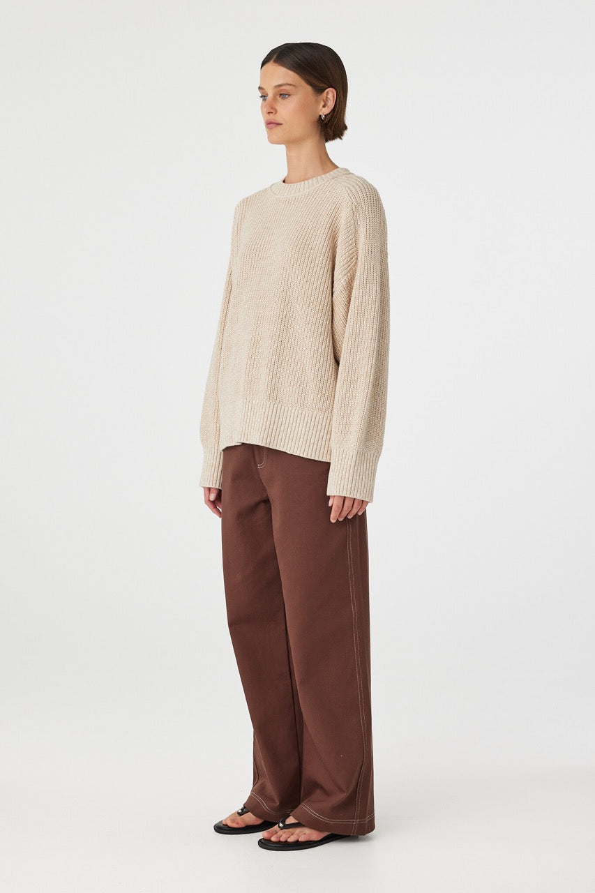 Side view of cream sweater showing raglan sleeves and relaxed fit