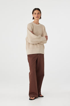 Front view of cream sweater styled with arms crossed