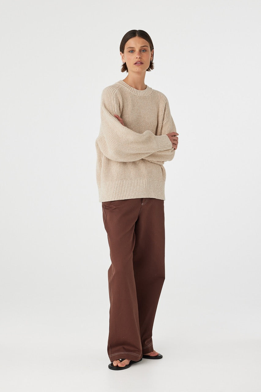 Front view of cream sweater styled with arms crossed