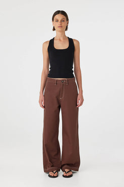 Full body front view of Sable Top black, racerback knit tank styled with brown pants.