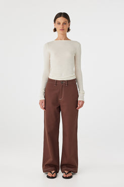 Full body front view of Aston Long Sleeve Top cream, slim fit semi-sheer knit styled with brown pants.