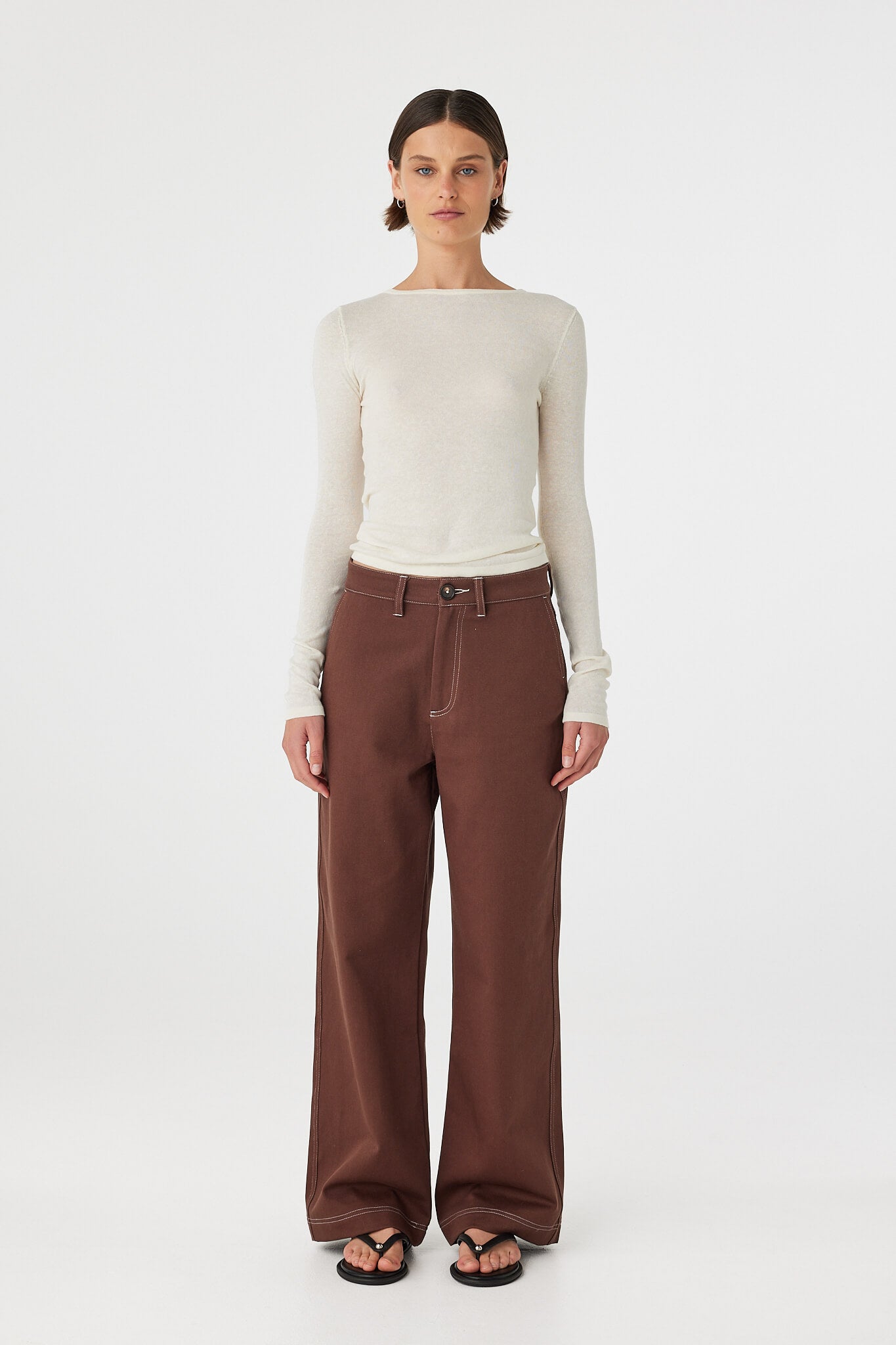 Full body front view of Aston Long Sleeve Top cream, slim fit semi-sheer knit styled with brown pants.
