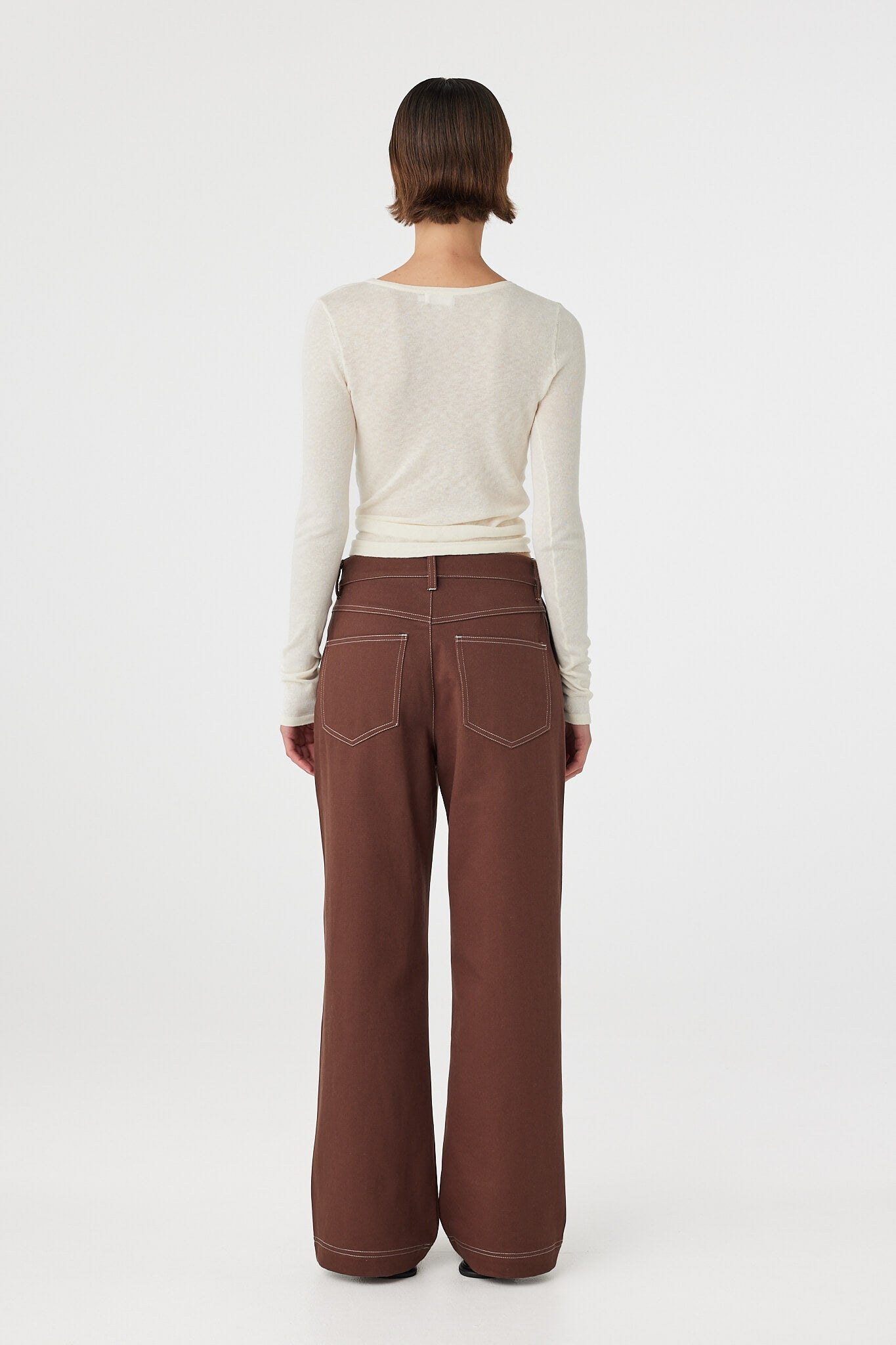 Back view of Aston Long Sleeve Top cream, semi-sheer knit showing close fit through the body.