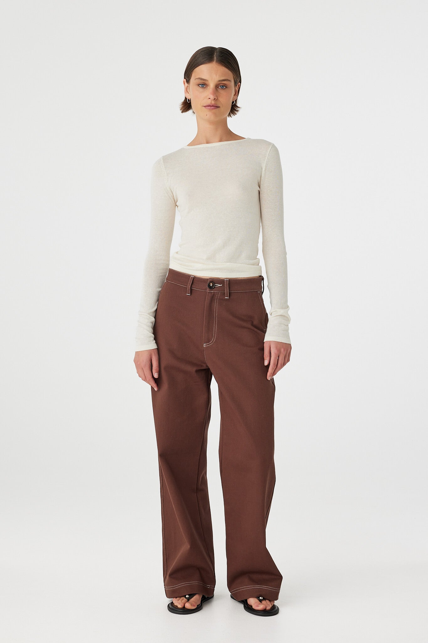 Front view of Aston Top cream, slim fit boat neck knit styled with brown wide-leg pants.