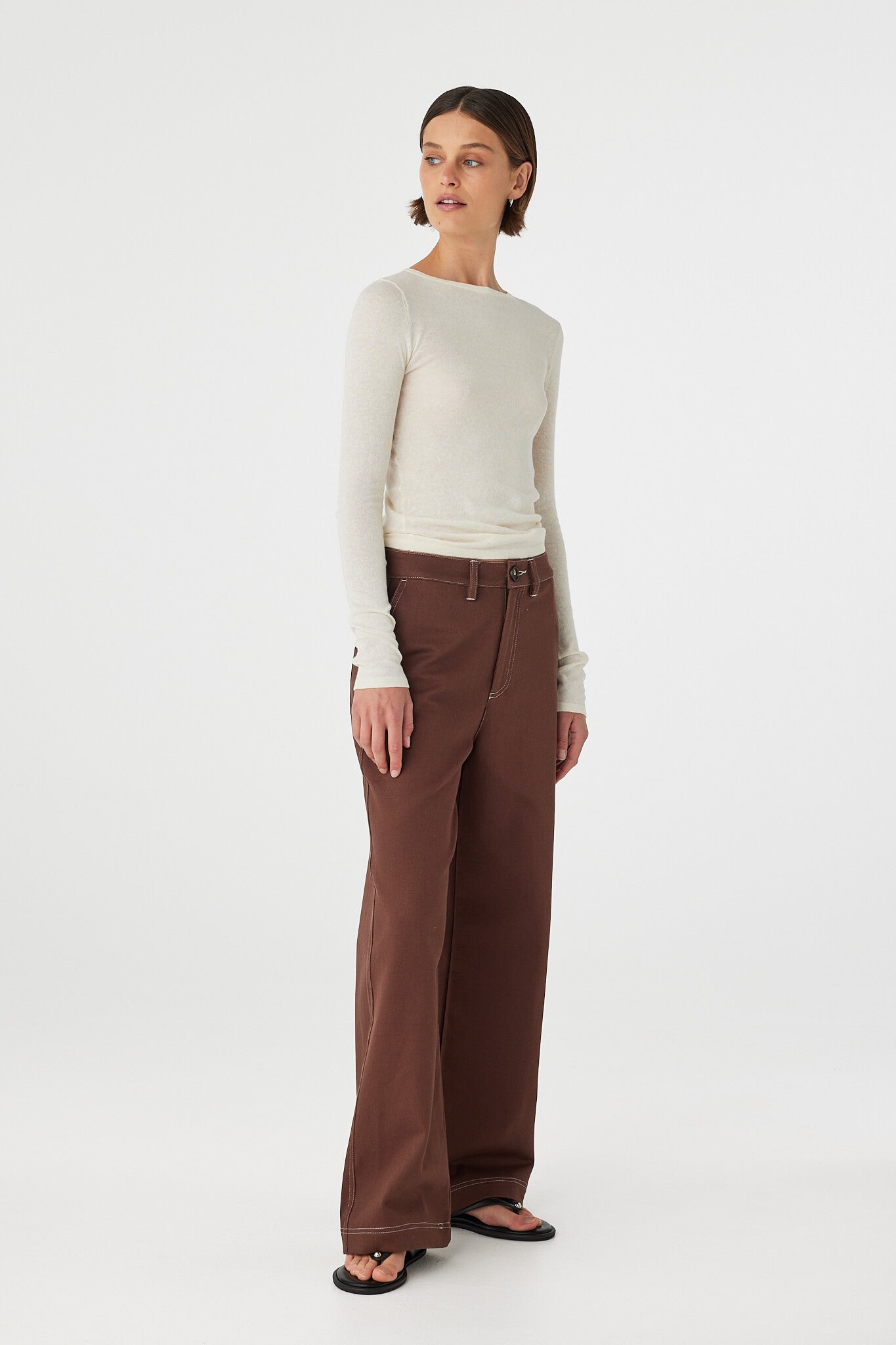 Angled side view of Aston Top cream, semi-sheer cotton–linen knit showing drape and sleeve length.
