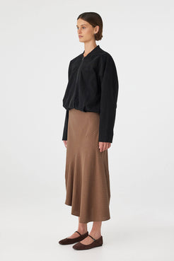 Outfit side view: black top with Alessia Skirt choc polka dot, cotton A-line skirt with asymmetrical hem