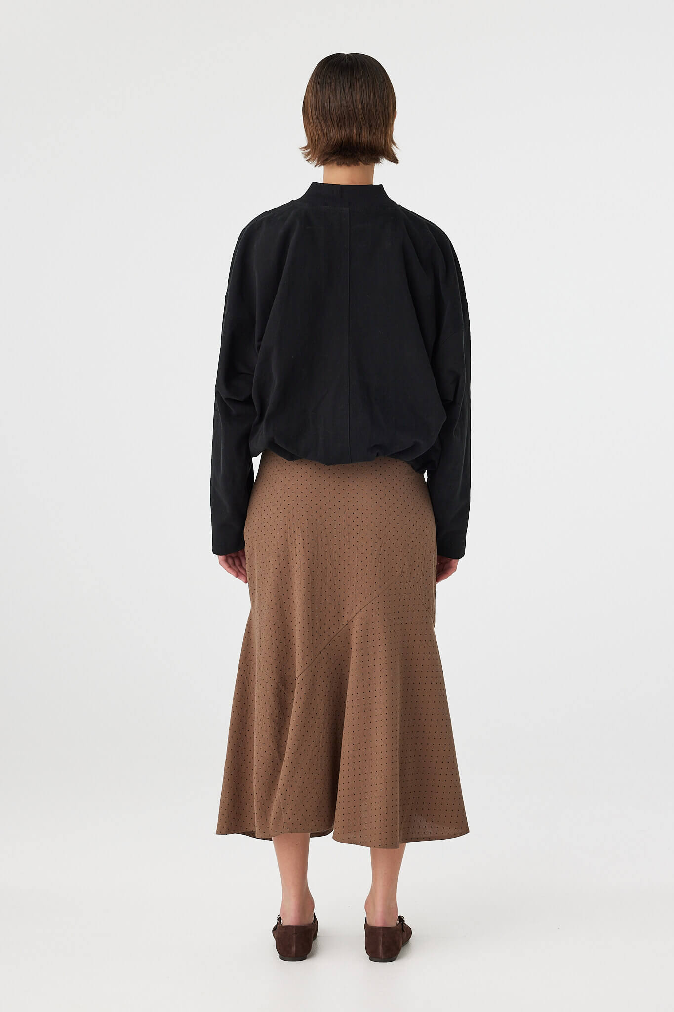 Back view of Alessia Skirt choc polka dot, A-line cotton skirt showing hem shape and drape.