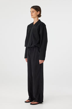 Side view of Rae Pant in black, fluid drape through the straight leg with elastic drawcord waist.