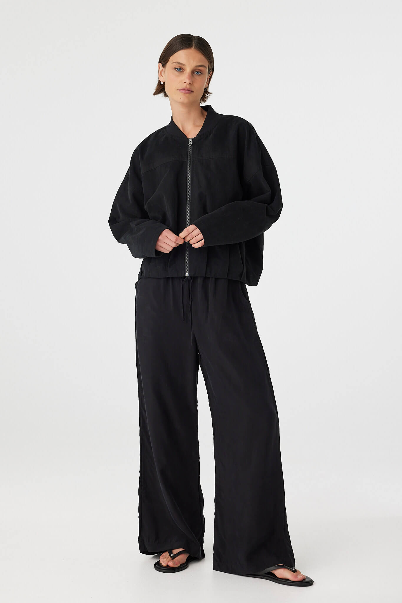 Full body front view of black bomber jacket with matching pants