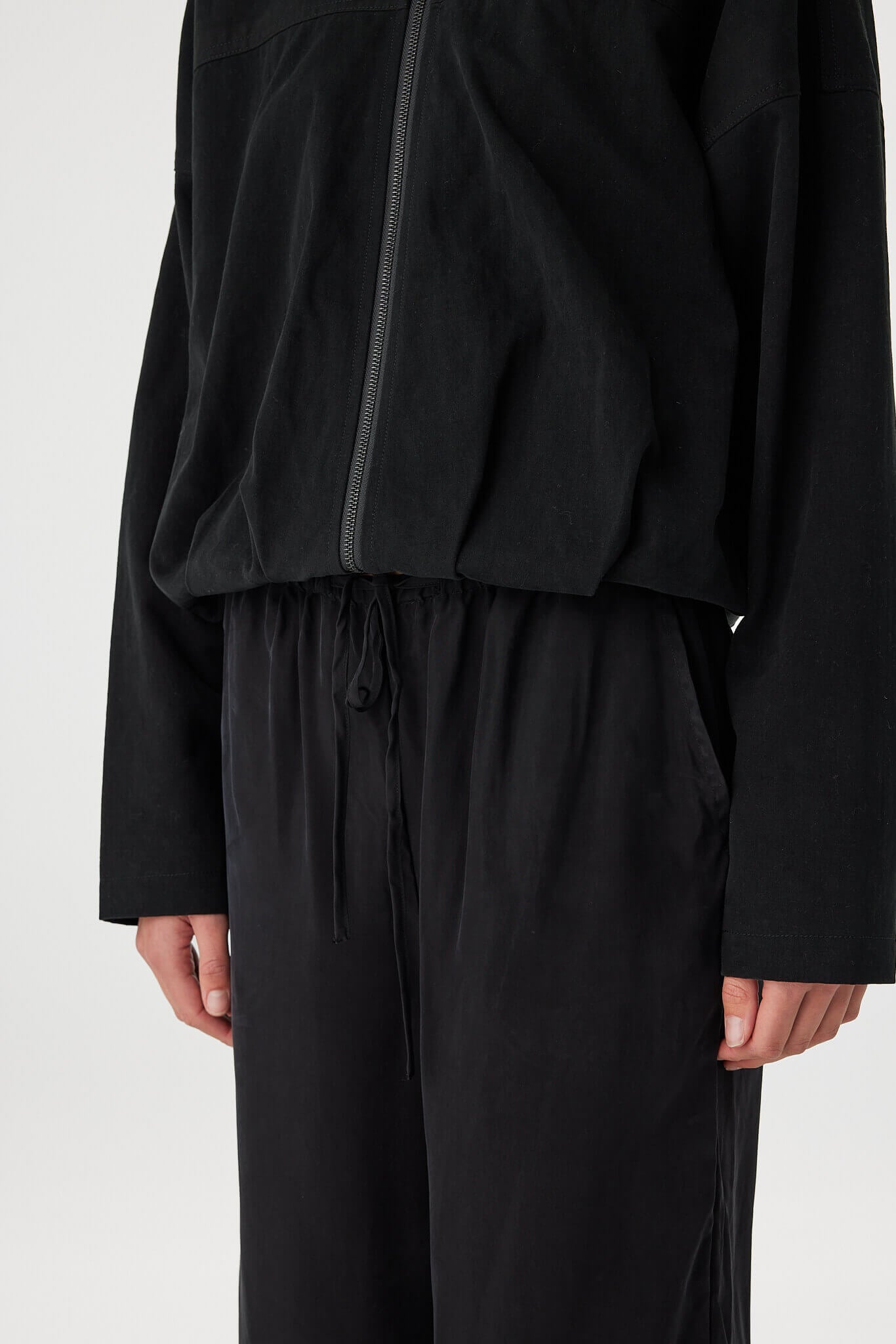 Close-up of black bomber jacket showing zipper and fabric detail