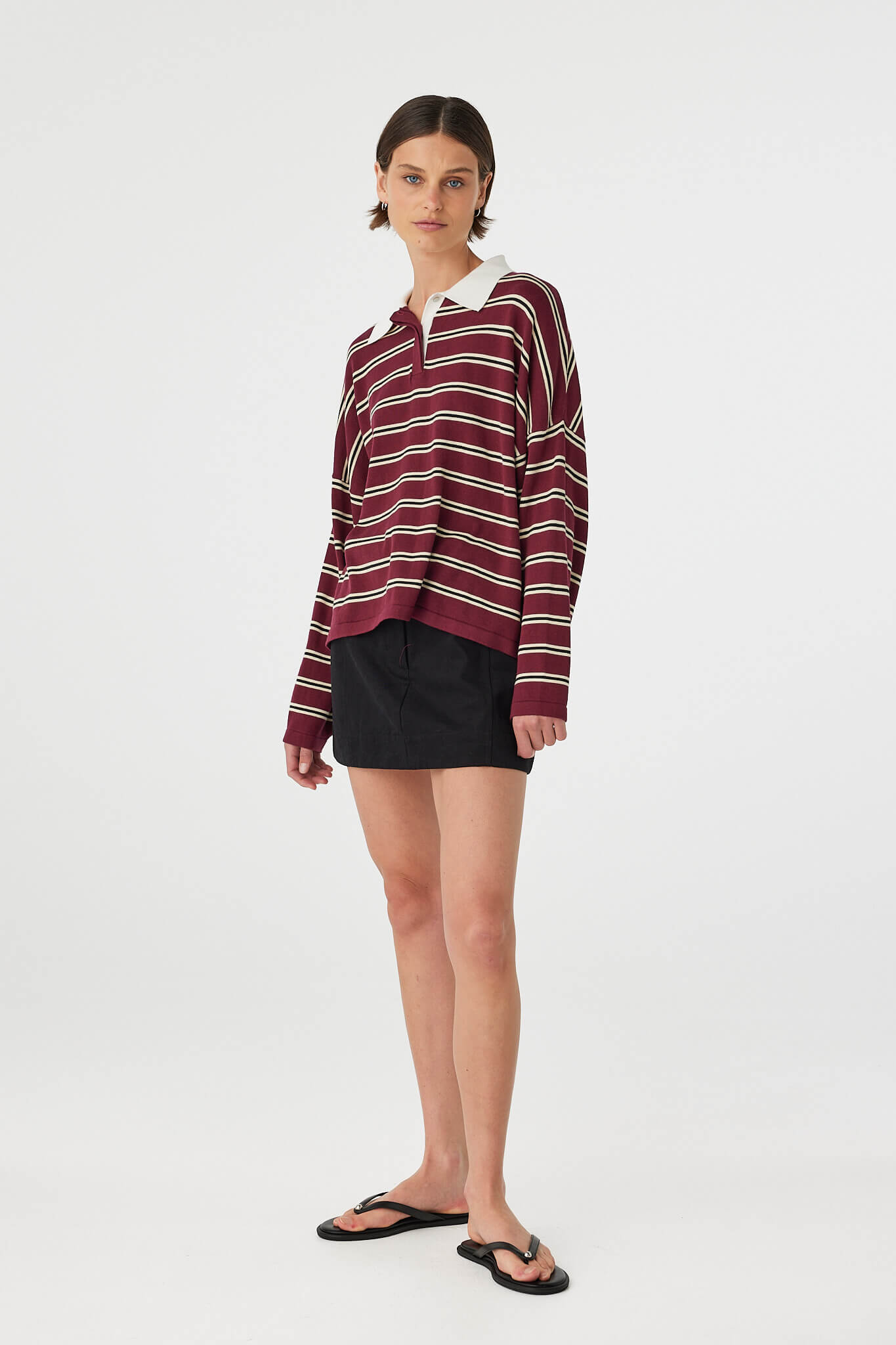 Model wearing Eames Mini Skirt black styled with striped top, mini skirt silhouette in outfit view.