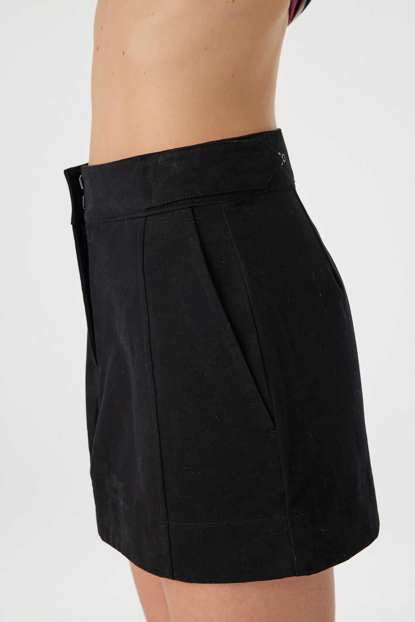 Close detail of Eames Mini Skirt black, side seam pocket opening and velvet-finish cotton texture.