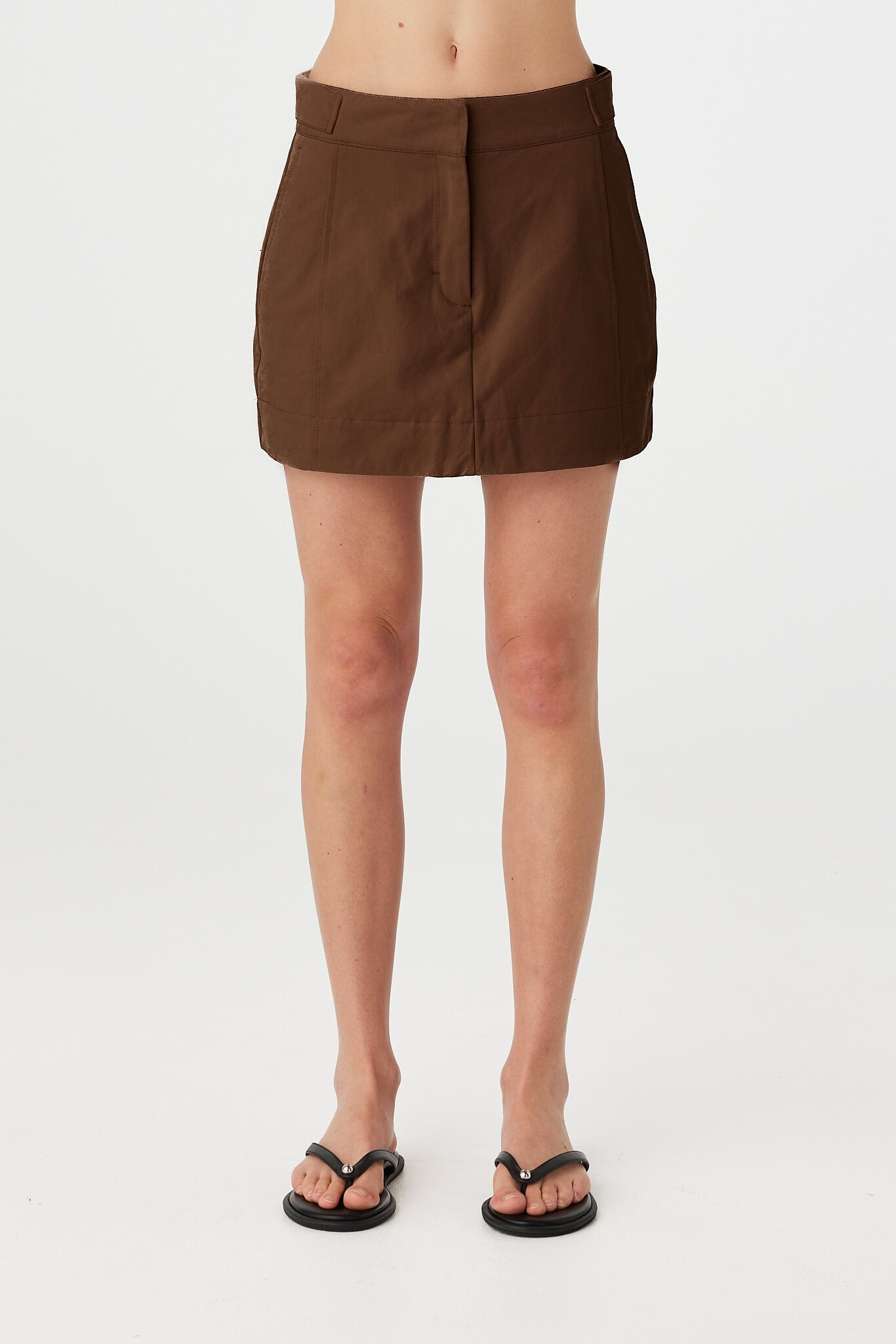 Eames mini skirt in espresso worn front on, showcasing the clean waistband, front fly closure and smooth velvet finish