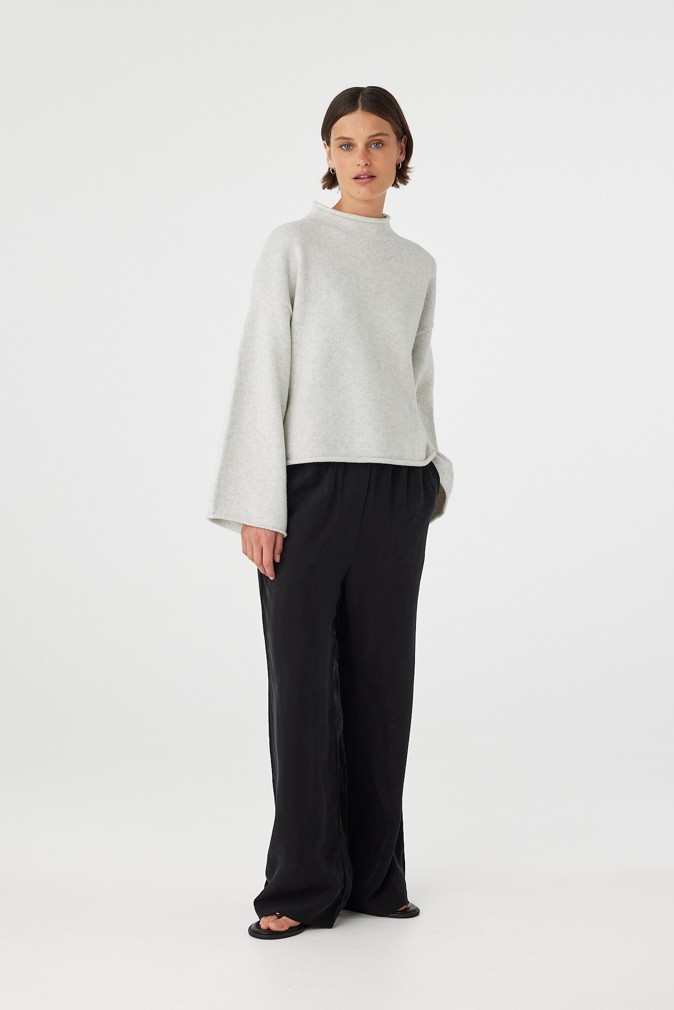 Maeve sweater in snow marle styled with black trousers, showcasing the soft knit texture, wide sleeves and natural drape