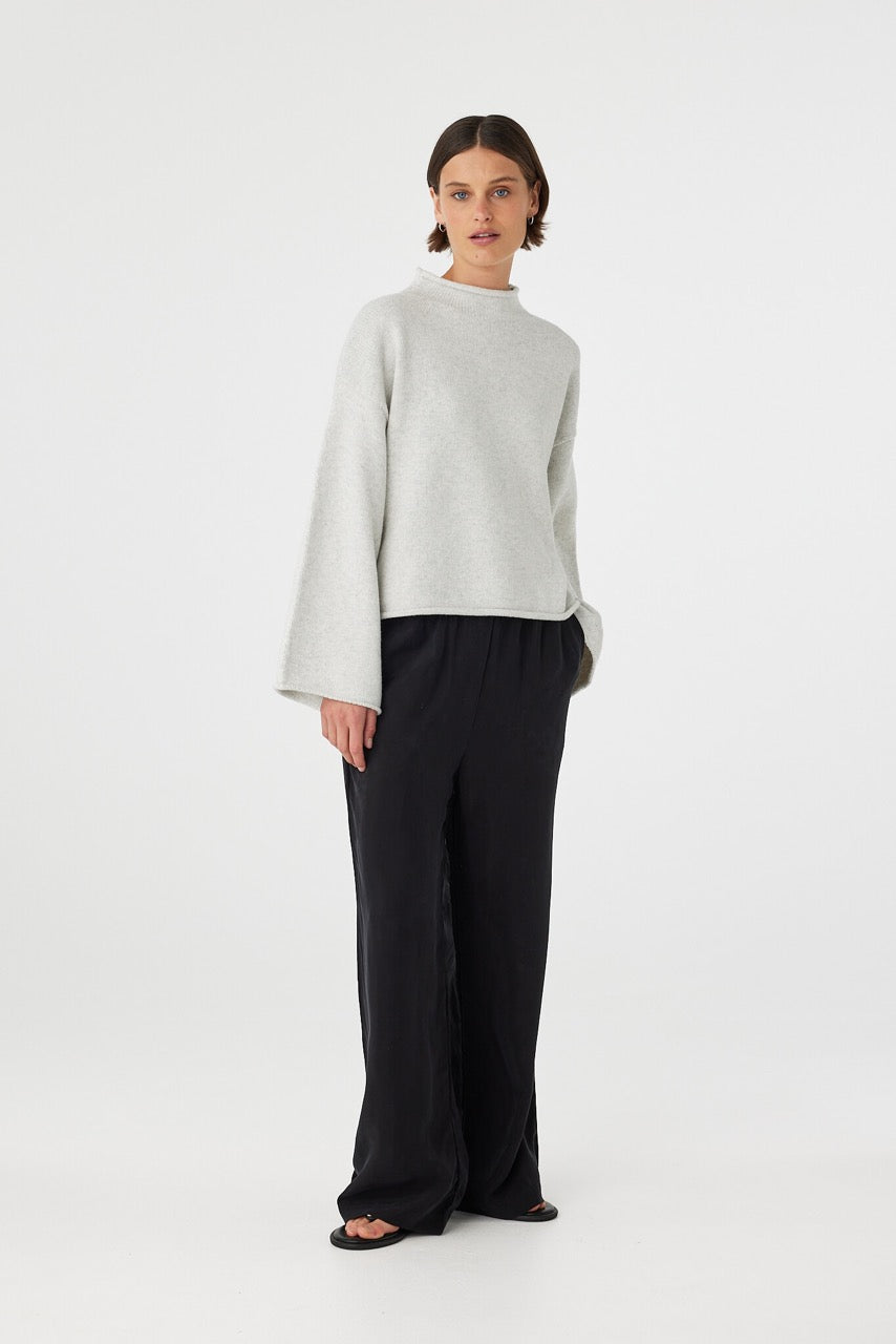 Maeve sweater in snow marle styled with black trousers, showcasing the soft knit texture, wide sleeves and natural drape