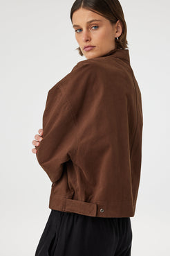 Eames jacket in espresso worn from a back angled view, showing the smooth finish, seam lines and side tab detail at the waistband
