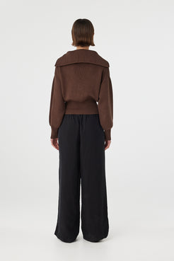 Marley zip sweater in espresso viewed from back, featuring the clean silhouette, ribbed texture and fitted waistband, styled with black pants and sandals