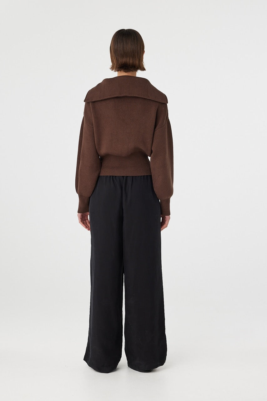 Marely zip sweater in espresso viewed from back, featuring the clean silhouette, ribbed texture and fitted waistband, styled with black pants and sandals