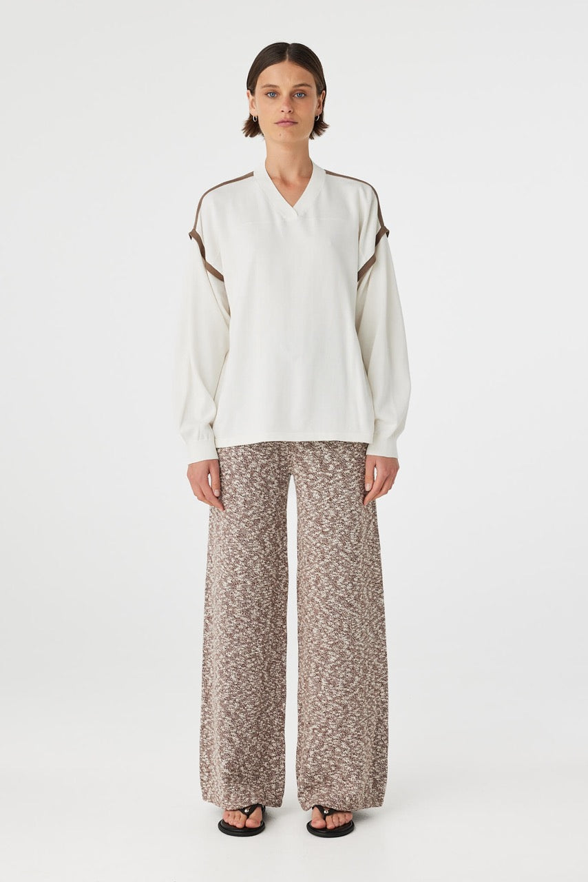 Eden long sleeve tee in cream and espresso worn front on, featuring an oversized slouchy fit, ribbed V-neckline and contrast shoulder detailing, styled with marled wide leg pants and sandals