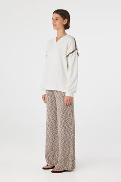 Eden long sleeve tee in cream and espresso shown in side profile, highlighting dropped shoulders, wide sleeves and relaxed drape, styled with marled pants