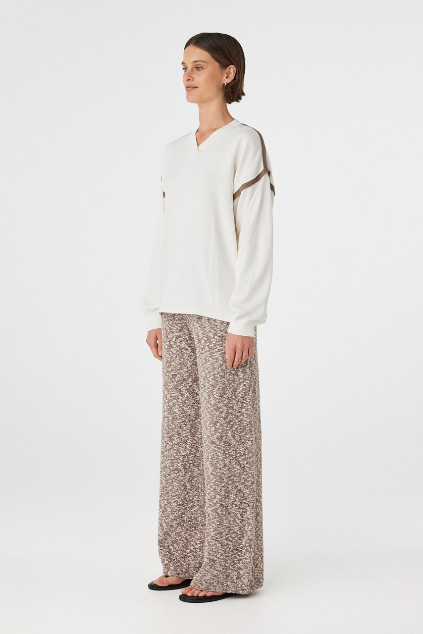 Eden long sleeve tee in cream and espresso shown in side profile, highlighting dropped shoulders, wide sleeves and relaxed drape, styled with marled pants
